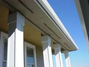 Close-up image of seamless gutters on a home with columns.